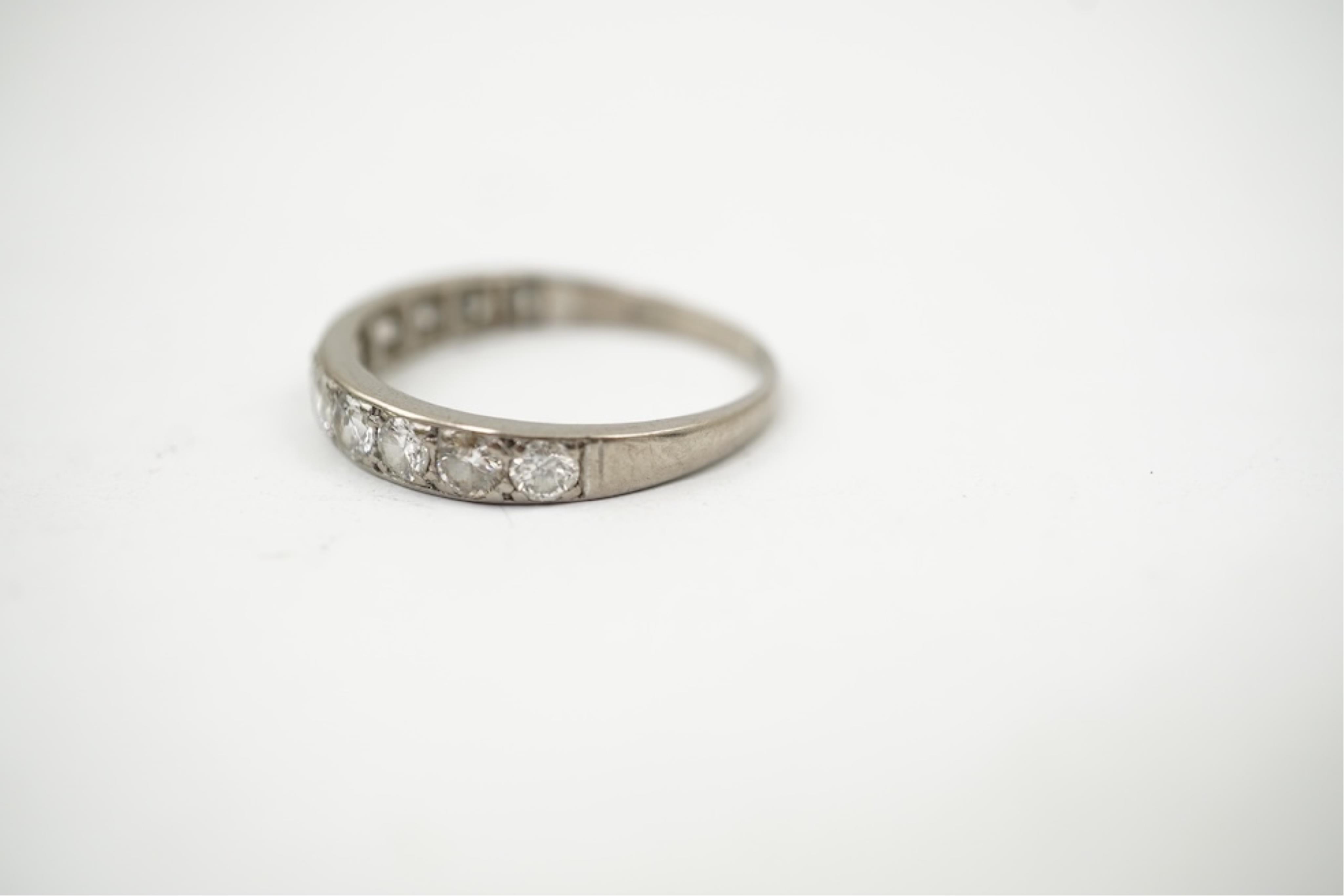 An 18ct white metal and graduated eleven stone diamond set half eternity ring, size P/Q. gross weight 3 grams.